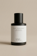 Skincare bottle with black cap and white label on a beige background